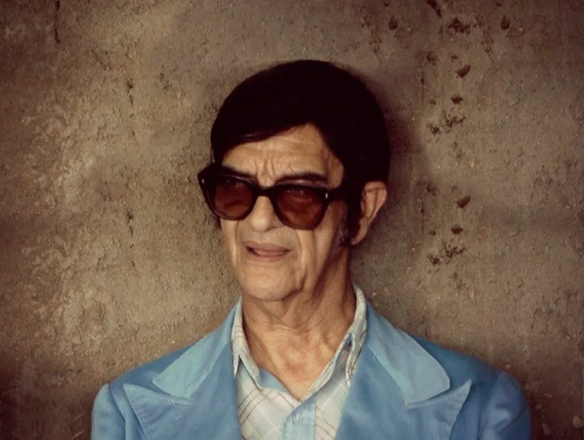 Retrato de Chico Xavier de óculos escuros, em tom contemplativo